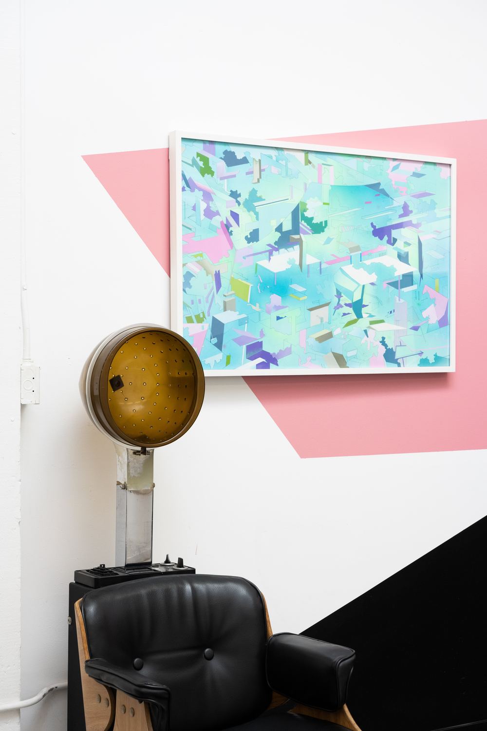 A framed blue and pink abstract artwork above a hood dryer and a black chair