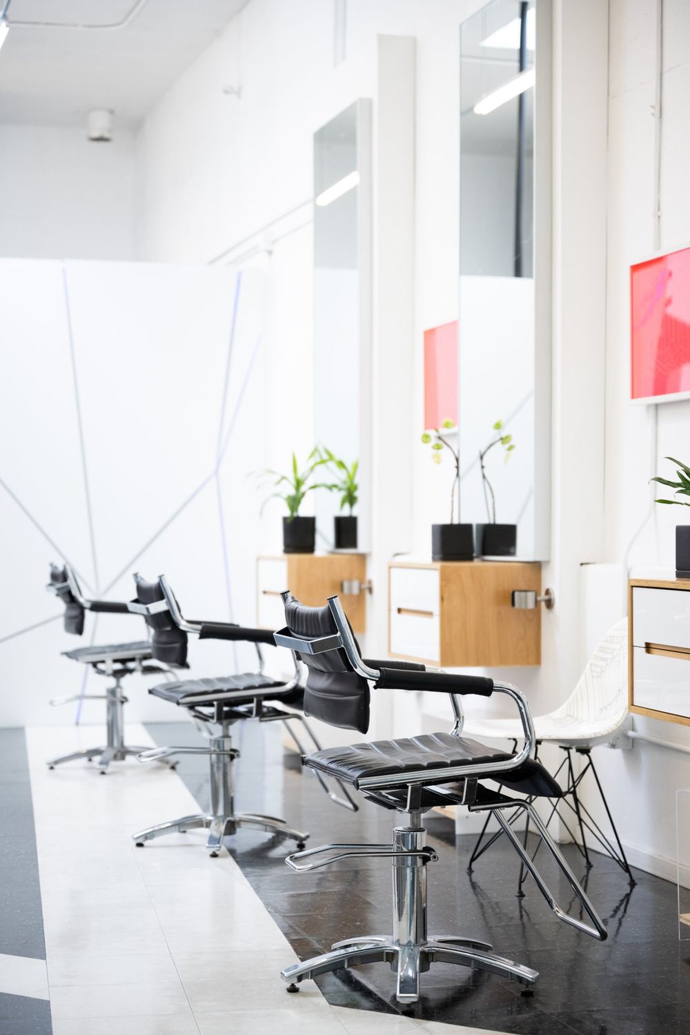 Three styling chairs with mirrors, plants and a patterned white side chair